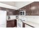 Kitchen with stainless appliances, white countertops, and dark wood cabinetry at 606 Beth Ave, Fort Lupton, CO 80621