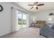 Bright living room with sliding glass doors to the backyard and a modern ceiling fan at 606 Beth Ave, Fort Lupton, CO 80621