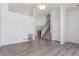 Open-concept living room features staircase, hardwood flooring and light-colored walls at 606 Beth Ave, Fort Lupton, CO 80621