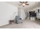 Cozy living room with neutral carpet, ceiling fan, and open access to the kitchen at 606 Beth Ave, Fort Lupton, CO 80621