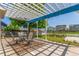 Charming patio with pergola, ideal for outdoor dining and relaxation, surrounded by a beautifully landscaped yard at 606 Beth Ave, Fort Lupton, CO 80621
