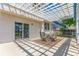 Inviting patio with a white pergola, dining set, and sliding glass doors for seamless indoor-outdoor living at 606 Beth Ave, Fort Lupton, CO 80621