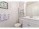 Cozy half-bath with white vanity, wall cabinet, and framed 'Bless Our Nest' artwork at 606 Beth Ave, Fort Lupton, CO 80621
