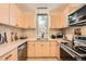 Well-designed kitchen featuring modern appliances, light wood cabinets, and a view from the window at 19624 E Girard Dr, Aurora, CO 80013