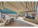 Large patio space complete with an outdoor kitchen, dining table, and retractable awning for shade at 19624 E Girard Dr, Aurora, CO 80013