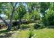 Spacious backyard with mature trees, green grass, and a unique decorative fence at 260 E Cornwall Ct, Lafayette, CO 80026