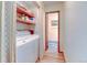 Functional laundry room with a washer, dryer, storage shelves, and an open doorway at 260 E Cornwall Ct, Lafayette, CO 80026