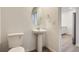 Powder room featuring pedestal sink and toilet with wood-look flooring at 14587 W 90Th Ln # B, Arvada, CO 80005