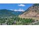 Aerial view of a valley with houses and a winding road, surrounded by lush green mountains and trees at 1890 Argentine St # C301, Georgetown, CO 80444
