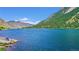 Beautiful lake view with a person sitting by the water and mountains in the background on a bright sunny day at 1890 Argentine St # C301, Georgetown, CO 80444