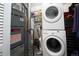 Efficient laundry room with stacked washer and dryer unit, shelving, and utility equipment at 1890 Argentine St # C301, Georgetown, CO 80444