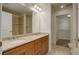 Bathroom features double sinks with cabinets, large mirror, shower and walk-in closet at 2200 S University Blvd # 313, Denver, CO 80210