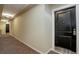 Hallway with neutral walls and carpet leads to a black door with silver hardware at 2200 S University Blvd # 313, Denver, CO 80210