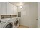 Bright laundry room with white washer, dryer, and cabinets at 2200 S University Blvd # 313, Denver, CO 80210