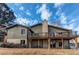 Back exterior view of home featuring a wooden deck, brick foundation, and well-manicured lawn at 6066 S Monaco Way, Centennial, CO 80111