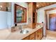 Rustic bathroom featuring wooden cabinets, double sinks, and diamond-patterned tile at 6066 S Monaco Way, Centennial, CO 80111