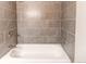 Bathtub with gray tile walls and bronze fixtures at 6066 S Monaco Way, Centennial, CO 80111