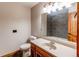 Bathroom featuring single vanity, toilet, and tile shower with wood accents at 6066 S Monaco Way, Centennial, CO 80111