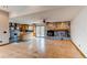 Spacious living room featuring a stone fireplace, wood floors, and access to the kitchen at 6066 S Monaco Way, Centennial, CO 80111