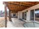 Covered patio with white brick and wood beams offers a shaded outdoor space for relaxation and entertainment at 6066 S Monaco Way, Centennial, CO 80111