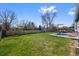 Spacious backyard with green grass, a patio with furniture, and a wood fence surrounding the perimeter at 6074 S Dudley Way, Littleton, CO 80123
