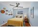 Cozy bedroom features a bed with colorful bedding, decor, and a ceiling fan at 6074 S Dudley Way, Littleton, CO 80123