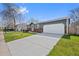 Home featuring a well-maintained lawn, long driveway, a white garage door, and stone accents at 6074 S Dudley Way, Littleton, CO 80123