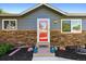 Close-up of home showcasing a striking front door, stone accents, and fresh landscaping that enhances curb appeal at 6074 S Dudley Way, Littleton, CO 80123