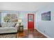 Bright living room features a decorative red door, hardwood floors, and a large window at 6074 S Dudley Way, Littleton, CO 80123