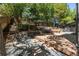 Serene backyard with stone landscaping, tiered wooden deck, mature trees and privacy fencing at 5951 S Akron Way, Greenwood Village, CO 80111