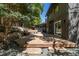 Backyard with wooden deck, stone walkway, and mature trees at 5951 S Akron Way, Greenwood Village, CO 80111