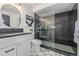 Modern bathroom features white vanity, glass shower with black tiling and patterned floors at 5951 S Akron Way, Greenwood Village, CO 80111