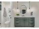 Stylish bathroom features an oval mirror over a green vanity with modern fixtures at 5951 S Akron Way, Greenwood Village, CO 80111