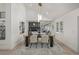Bright dining room featuring a long table, modern lighting fixture, neutral decor, and an open floor plan at 5951 S Akron Way, Greenwood Village, CO 80111