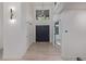 Bright and airy foyer with a modern light fixture, sleek black double doors, and light hardwood floors at 5951 S Akron Way, Greenwood Village, CO 80111