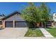 Charming home exterior with a three-car garage, concrete driveway, and lush landscaping at 5951 S Akron Way, Greenwood Village, CO 80111