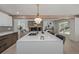 Bright kitchen island featuring stone countertops, modern appliances, and a view to the living room at 5951 S Akron Way, Greenwood Village, CO 80111