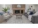 Cozy living room featuring a stone fireplace, modern decor, neutral furniture, and natural light at 5951 S Akron Way, Greenwood Village, CO 80111