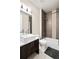 Well-lit bathroom showcasing a vanity with a square sink and a tiled shower-tub combo at 32 Jackson St, Denver, CO 80206
