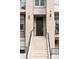 A close-up of the front entrance featuring a large black door, brick facade, and concrete stairs at 32 Jackson St, Denver, CO 80206