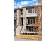 A close up exterior of the townhouse featuring a gray roof, brick facade, and balcony with seating at 32 Jackson St, Denver, CO 80206