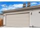 View of the detached two-car garage with two lights and an off-white exterior at 32 Jackson St, Denver, CO 80206