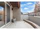 View of the patio area with exposed brick walls, potted plants, and black railings at 32 Jackson St, Denver, CO 80206