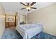 Bedroom showcasing blue carpet, ceiling fan, and access to an ensuite bathroom at 9650 Huron St # 22, Thornton, CO 80260