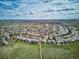 Stunning aerial view of a community nestled within lush greenery under a partly cloudy sky at 10060 Oak Leaf Way, Highlands Ranch, CO 80129