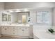 Bright bathroom featuring dual sinks, a large mirror, and a corner soaking tub, creating a spa-like atmosphere at 10060 Oak Leaf Way, Highlands Ranch, CO 80129