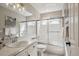 Bright bathroom featuring tile countertops, shower-tub combo with sliding doors, and modern fixtures at 10060 Oak Leaf Way, Highlands Ranch, CO 80129