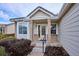 Inviting front porch of a single-story home with brick accents and manicured landscaping at 10060 Oak Leaf Way, Highlands Ranch, CO 80129
