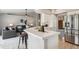 Inviting kitchen area features a breakfast bar, white cabinets, and modern stainless appliances at 10060 Oak Leaf Way, Highlands Ranch, CO 80129