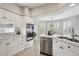 Well-lit kitchen featuring white cabinets, stainless steel appliances, and tiled countertops and flooring at 10060 Oak Leaf Way, Highlands Ranch, CO 80129